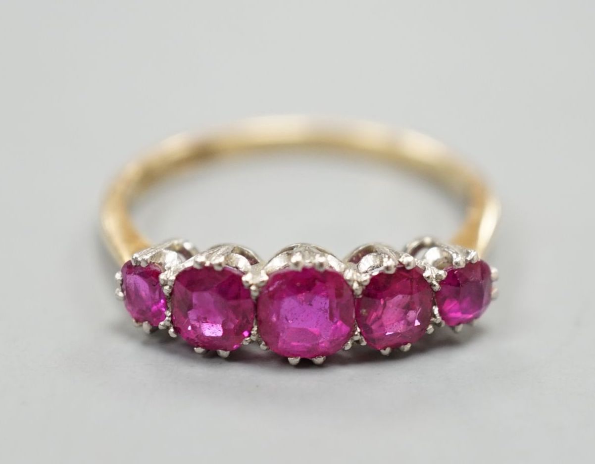 An early 20th century 18ct and plat, graduated five stone ruby set half hoop ring, size Q, gross weight 3.2 grams.